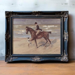 A framed painting shows a rider on horseback beside a dog on a sandy beach, with ocean waves in the background. The tone is serene and nostalgic.