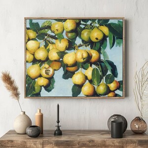 A framed painting of ripe yellow pears on leafy branches hangs on a textured white wall. Below, a wooden shelf holds vases and candles, creating a serene, artistic atmosphere.