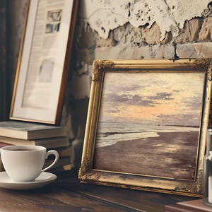 A cozy scene with a framed ocean sunset painting on a rustic shelf. A white coffee cup is nearby, and the backdrop features a textured, worn wall.