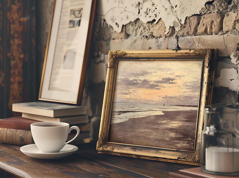 A cozy scene with a framed ocean sunset painting on a rustic shelf. A white coffee cup is nearby, and the backdrop features a textured, worn wall.