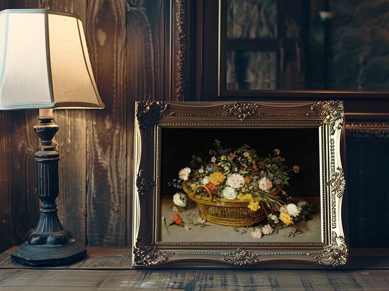 A framed painting of a floral basket filled with vibrant flowers, set on a wooden table beside an ornate lamp, creating a warm, vintage ambiance.