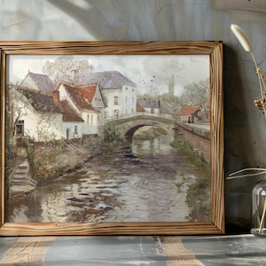 Painting of a serene village scene with a stone bridge over a river, surrounded by rustic houses and trees. Framed in wood, evoking a peaceful, nostalgic mood.