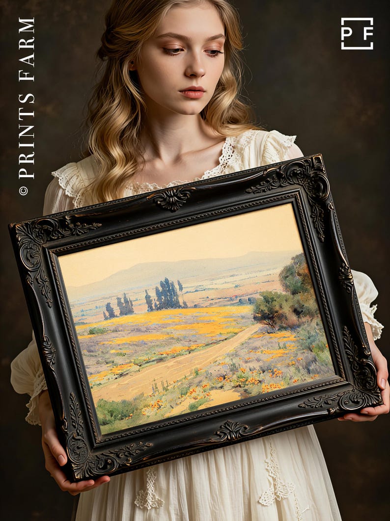 Young woman in a white dress holds an ornate framed painting of a scenic landscape with vibrant yellow fields and distant hills, conveying tranquility.