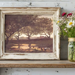 Framed landscape painting with trees and ducks on a rustic shelf beside a mason jar filled with wildflowers. Calm and serene atmosphere.