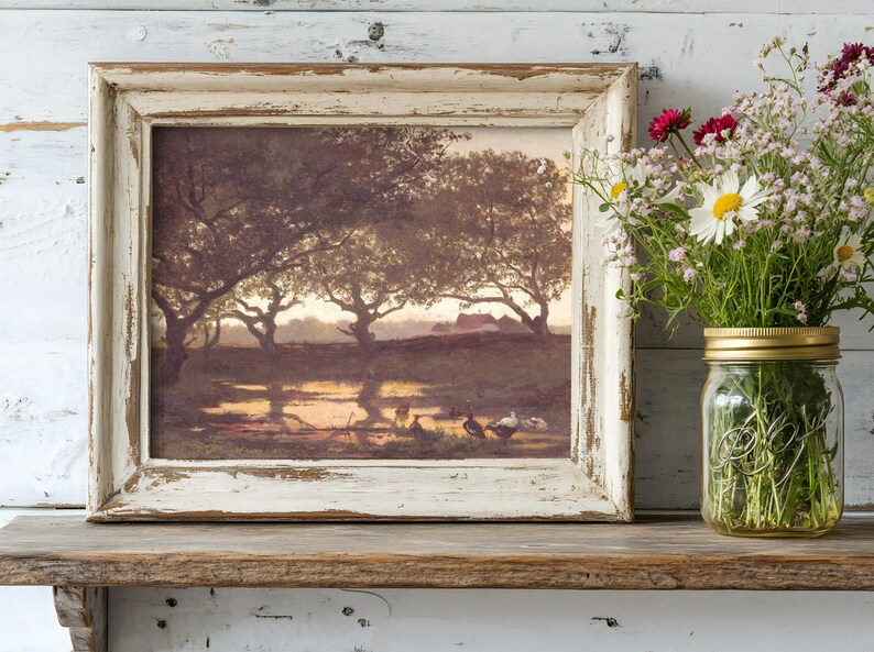 Framed landscape painting with trees and ducks on a rustic shelf beside a mason jar filled with wildflowers. Calm and serene atmosphere.