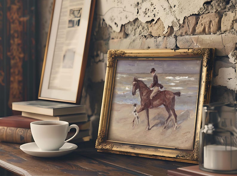 A framed painting on a rustic shelf shows a rider on a horse at the beach, accompanied by a dog. Nearby are books, a cup, and a candle, evoking a cozy mood.