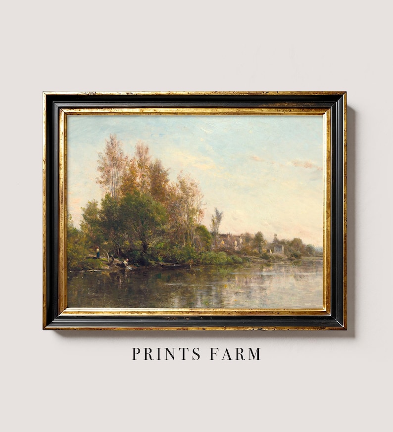 An antique landscape painting depicting a serene river scene with trees, a small boat, and buildings in the distance. The artwork is framed in a black and gold ornate frame, adding to its vintage appeal.