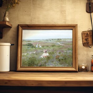 A rustic kitchen scene features a wooden-framed painting of a serene landscape with figures in a field. Nearby are jars, a candle, and a flower vase.