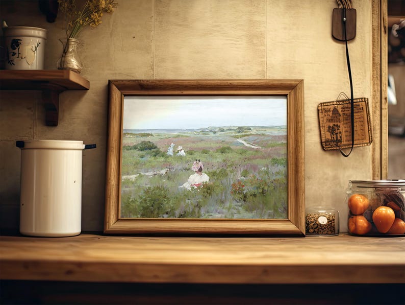 A rustic kitchen scene features a wooden-framed painting of a serene landscape with figures in a field. Nearby are jars, a candle, and a flower vase.