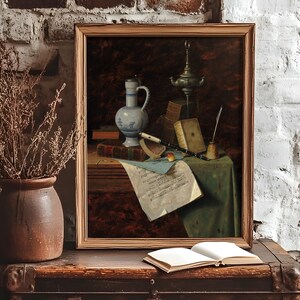 A framed still life painting on a rustic table against a white brick wall. The table holds a ceramic vase with dried branches and an open book. The painting features various objects, including a jug, books, a candle, and sheet music, conveying a vintage, scholarly atmosphere.