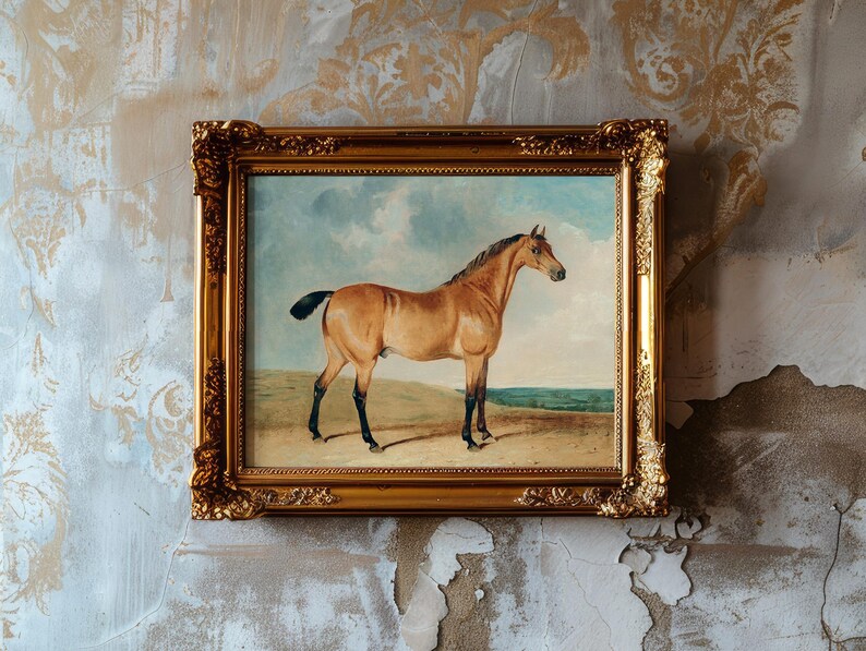 A framed painting of a horse with a sandy backdrop hangs on a textured, aged wall. The ornate gold frame contrasts with the worn wallpaper.