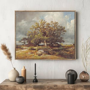 Painting of a large tree under a cloudy sky, framed and hung above a rustic wooden table. The table holds vases and a black candle, creating a serene atmosphere.