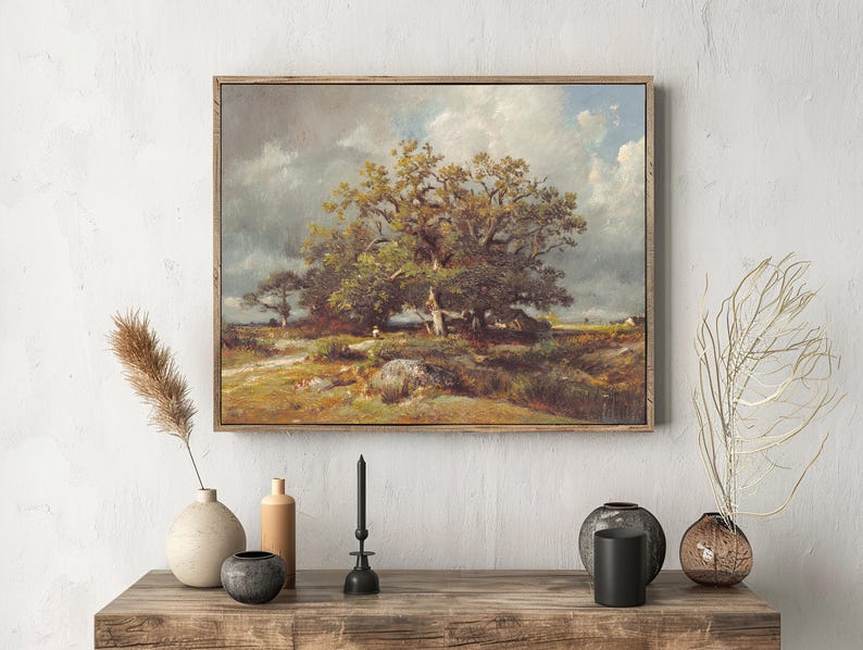Painting of a large tree under a cloudy sky, framed and hung above a rustic wooden table. The table holds vases and a black candle, creating a serene atmosphere.