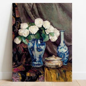 Painting of a still life with white roses in a blue vase, a matching blue pitcher, and a small bowl on a draped table, exuding a serene elegance.