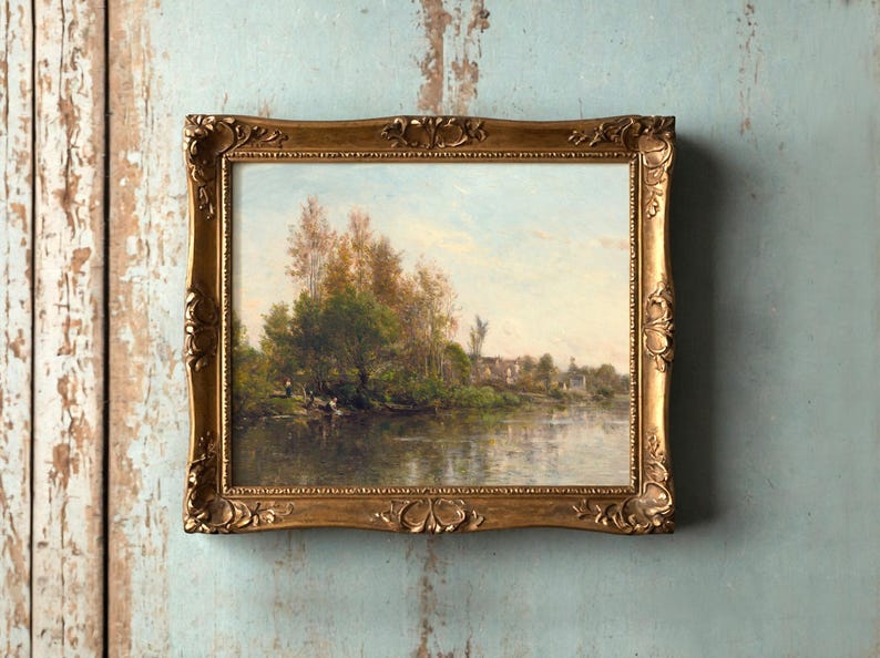 A framed landscape painting on a textured, weathered blue wall. The serene scene features a river, lush trees, and a quaint village, evoking calmness.