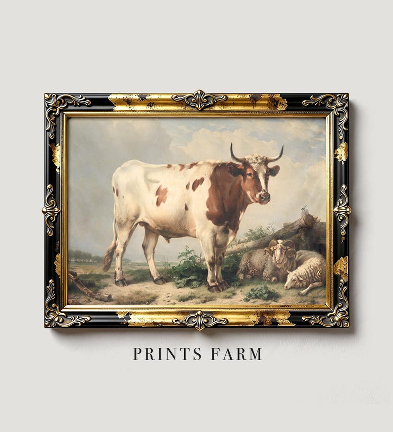 Framed artwork of a brown and white cow with sheep lying beside it, set in a rural landscape with a cloudy sky. Ornate black and gold frame.