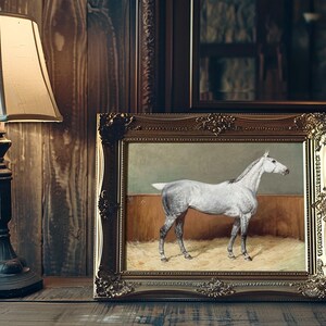 Framed painting of a white horse stands on a wooden shelf beside an ornate lamp. The scene exudes a warm, vintage ambiance with rich tones.