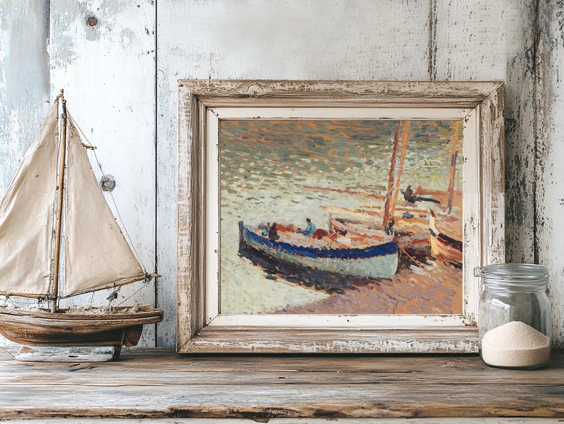 Framed impressionist painting of boats on a serene sea, displayed on a wooden shelf. Nearby, a model sailboat and a jar of sand create a coastal feel.