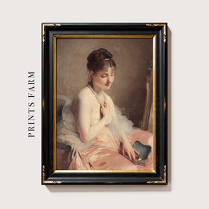 A vintage portrait of a seated woman in a pink dress, holding a blue fan, looking down with a serene expression. The image is framed in black and gold.