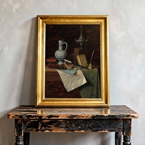 Framed still-life painting on a rustic table. Features a jug, candlestick, books, and documents, conveying a vintage and serene mood.