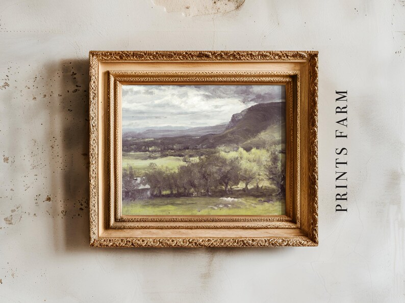 Framed landscape painting on a textured wall, featuring lush green fields and distant mountains under a cloudy sky. Text "PRINTS FARM" on the side.