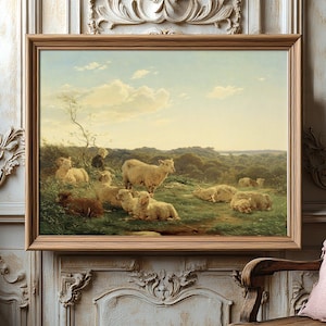 A serene painting of sheep grazing on a lush hillside, framed in wood, hangs on an ornate wall, exuding a peaceful, pastoral ambiance.