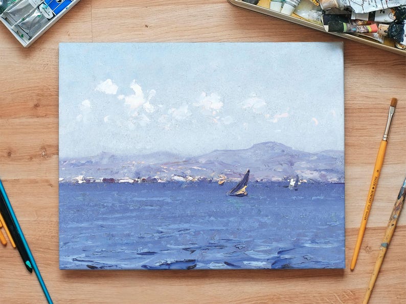 A painting of a sailboat on a serene blue sea with distant mountains and fluffy clouds. Surrounding are art supplies on a wooden table, creating a calm and creative atmosphere.