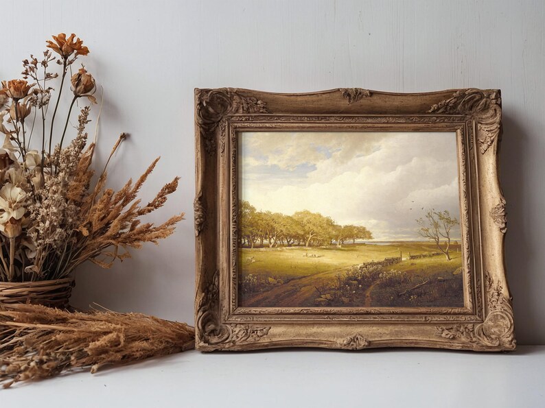 A rustic painting in an ornate frame shows a serene, sunlit landscape with trees and a path. Dried flowers in a basket are nearby, adding warmth.