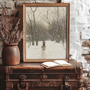 Framed winter scene on a rustic trunk against a brick wall. A painting depicts a snowy forest with a person on a path, creating a serene and nostalgic mood.