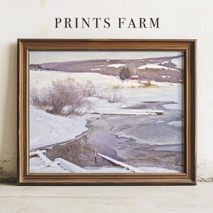Framed winter landscape painting with snowy hills and a river under a cloudy sky. Calm, serene scene. "Prints Farm" text is above.