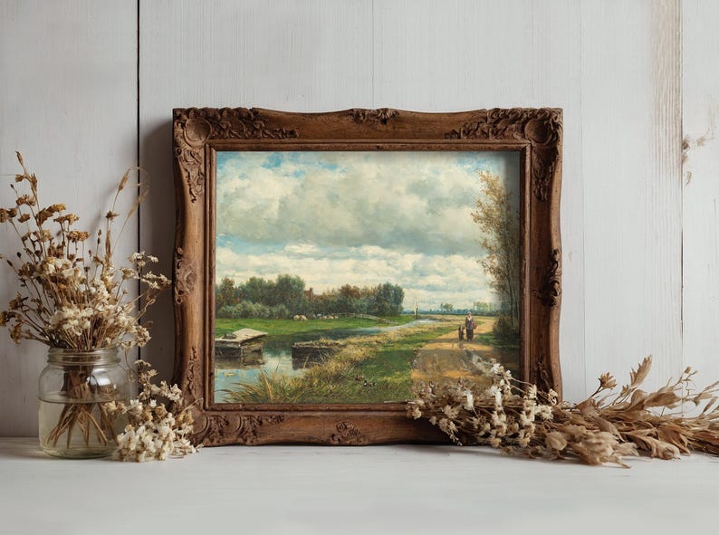 A framed landscape painting shows a serene riverside path under a cloudy sky, with two figures walking. Dried flowers in jars sit beside it, adding rustic charm.