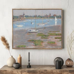 A painting of sailboats on a calm lake, with green patches and a distant town under a cloudy sky, hangs above a wooden table with vases and candles.