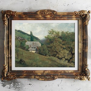 Vintage landscape painting in an ornate brown and gold frame. It depicts a rural scene with a house, lush greenery, and rolling hills under a cloudy sky.