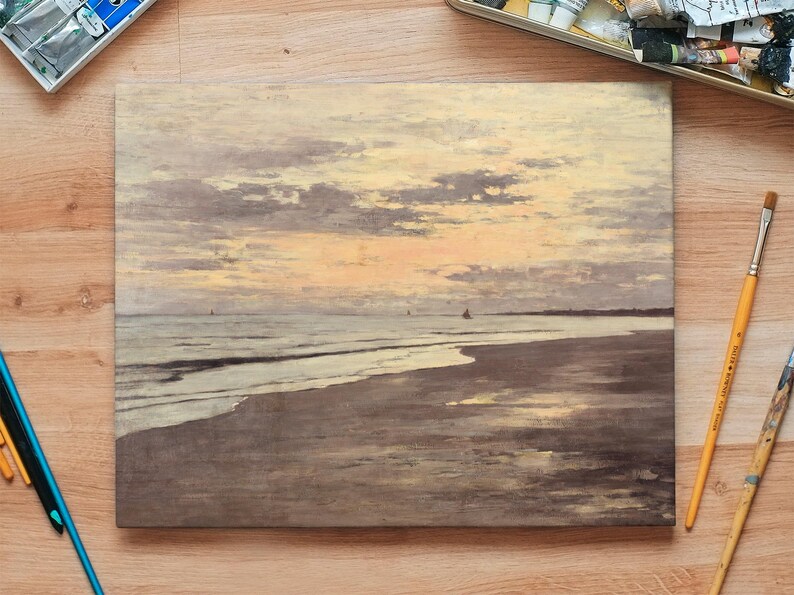 Painting of a serene sunset over the ocean, with a sandy beach in the foreground. Art supplies, including brushes and paints, surround the artwork.