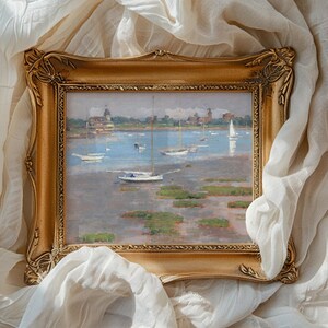 A framed painting of a serene harbor with sailboats on calm water, surrounded by a soft white fabric. The scene conveys tranquility and elegance.