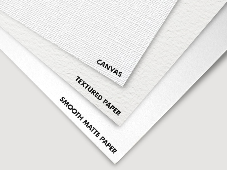 A close-up image showing the different textures and types of paper, with labels indicating from top to bottom: canvas, textured paper, and smooth matte paper. The papers are layered, showcasing their distinct surfaces and finishes.