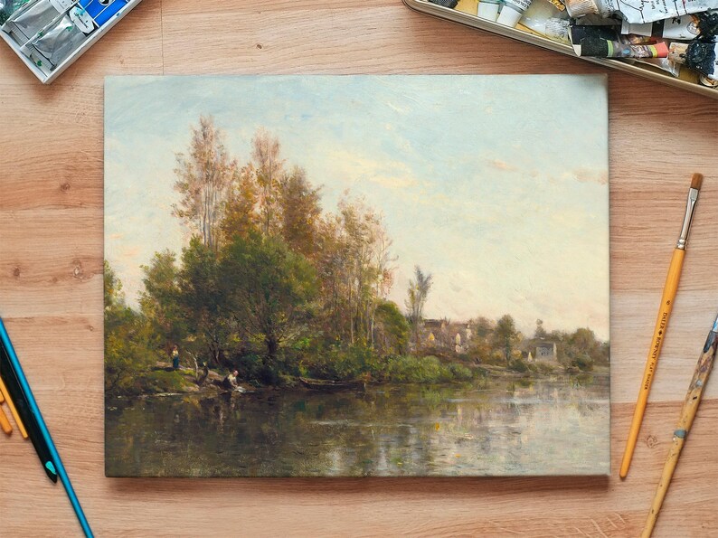 An oil painting depicting a serene landscape with a river, trees, and a distant village. The artwork features a palette of greens, browns, and blues, with reflections in the water. Paintbrushes and paint trays are visible.