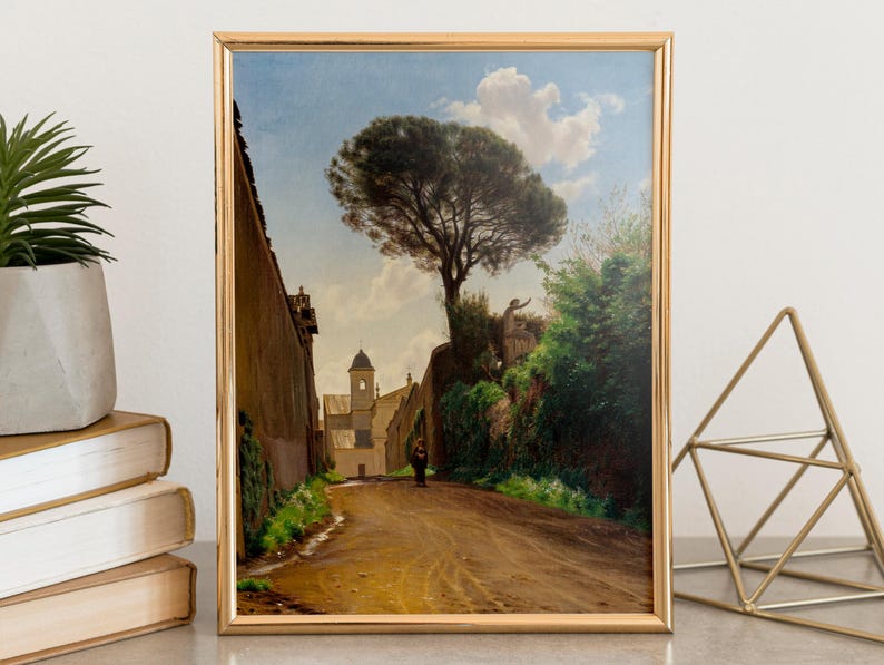 Framed painting of a serene landscape features a winding path, tall tree, and distant church under a blue sky with fluffy clouds. Peaceful ambiance.