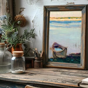 A rustic wooden desk features glass bottles and wildflowers beside a framed painting of a boat on serene water, evoking a calm, artistic atmosphere.
