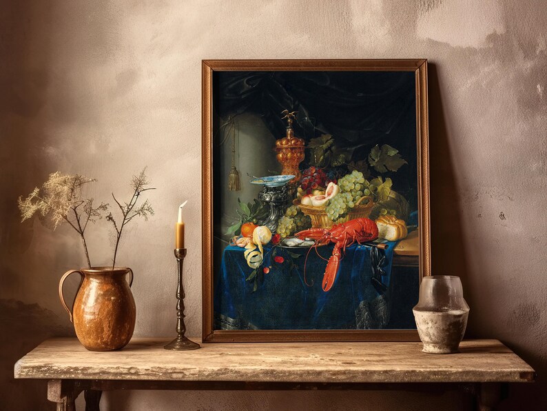 A framed still-life painting on a wooden shelf depicts a lavish spread of fruit and a lobster on a blue cloth. Nearby, a candle, pottery, and a small vase.