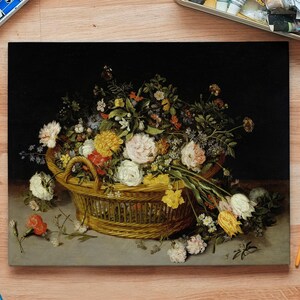 A detailed painting of a wicker basket overflowing with colorful flowers on a wooden table, surrounded by art supplies, evokes a creative, serene ambiance.