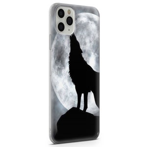 May include: A clear phone case with a black silhouette of a wolf howling at a full moon.
