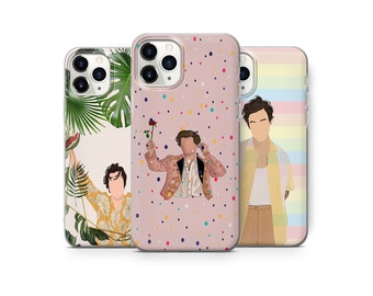 May include: Three phone cases with different designs. The first case has a pink background with colourful polka dots and a cartoon image of a person wearing a jacket. The second case has a white background with green leaves and a cartoon image of a person wearing a yellow shirt. The third case has a rainbow striped background with a cartoon image of a person wearing a yellow shirt and a blue jacket.