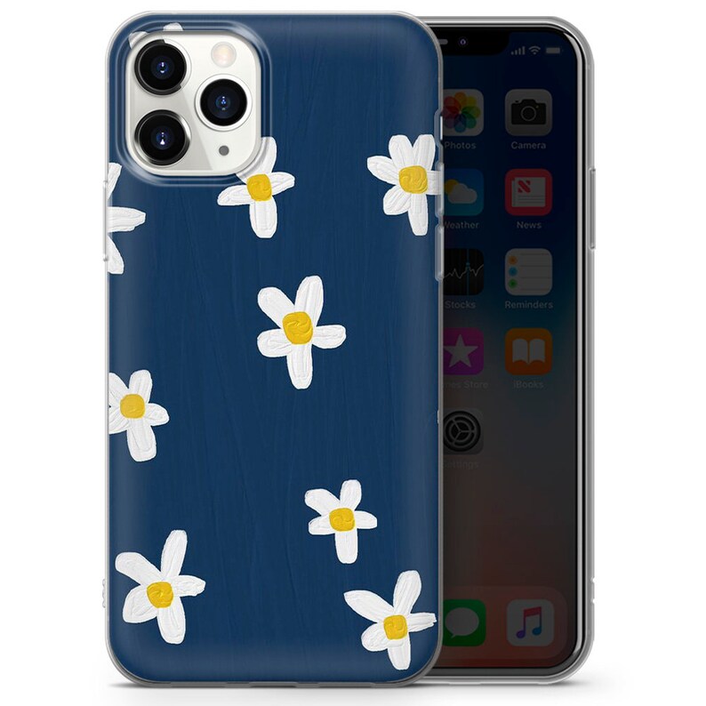 May include: A clear phone case with a navy blue background and a white daisy pattern. The daisies have yellow centers.