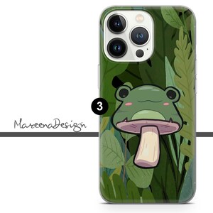 Op de afbeelding: Een transparante telefoonhoes met een groene kikker die op een paddenstoel zit. De kikker heeft een groen lichaam, witte ogen en een roze mond. De achtergrond is een groen en bruin bladmotief.