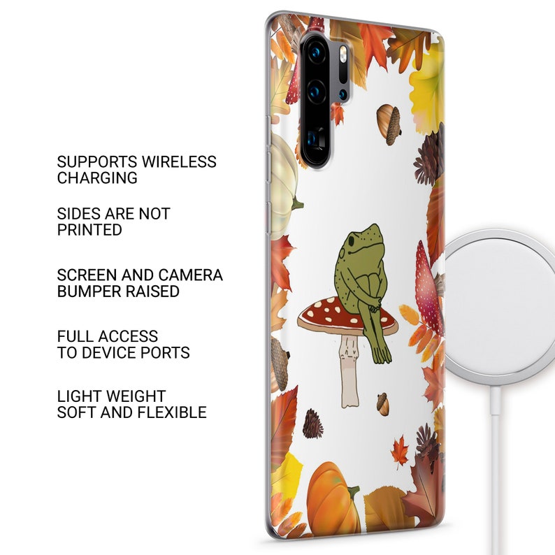 Op de afbeelding: Een transparante telefoonhoes met een witte achtergrond en een kleurrijk herfstbladerenontwerp. Een groene kikker zit op een rode en witte paddenstoel. De hoes ondersteunt draadloos opladen en heeft een verhoogde bumper om het scherm en de camera te beschermen.