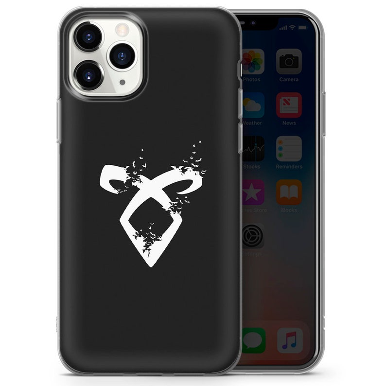 May include: A black phone case with a white symbol of a circle with a cross inside, surrounded by small white birds. The symbol is a popular design from the book series "The Mortal Instruments" by Cassandra Clare.