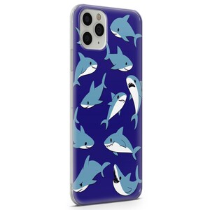 Pu&ograve; includere: Una custodia per telefono trasparente con sfondo blu e un motivo di squali bianchi di cartoni animati. La custodia ha un ritaglio per l'obiettivo della fotocamera.