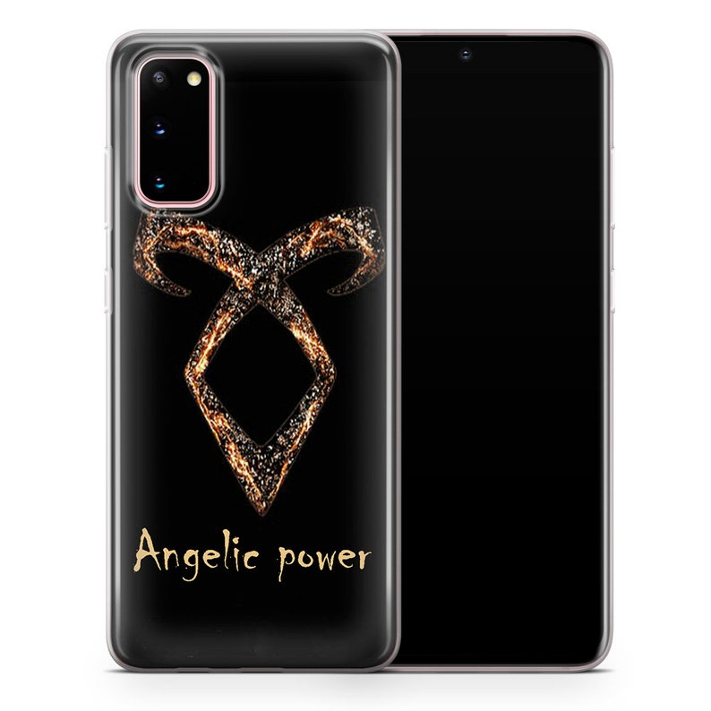May include: A clear phone case with a black background and a gold angelic power symbol. The symbol is made up of a series of lines and dots that create a swirling effect. The text "Angelic power" is written in gold below the symbol.