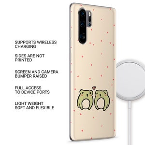 Op de afbeelding: Een transparante telefoonhoes met een lichtbeige achtergrond en een patroon van kleine rode hartjes. Twee groene kikkers bevinden zich in het midden van de hoes en kijken elkaar aan. De kikker links heeft een klein hartje boven zijn kop. De hoes ondersteunt draadloos opladen.